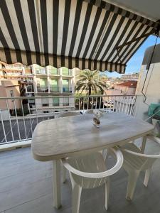 uma mesa branca e cadeiras numa varanda em Apartment Juan Les Pins in the heart of town with its merchants em Juan-les-Pins