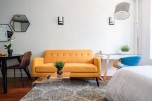 a living room with a yellow couch and a table at 24-10 Studio Prime Gramercy WD in Unit in New York