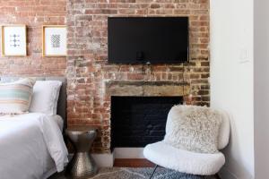 un salon avec une cheminée et une télévision sur un mur en briques dans l'établissement 24-10 Studio Prime Gramercy WD in Unit, à New York
