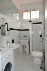 Baño blanco con lavabo y aseo en Casa Vacanze Adele, en Sciacca