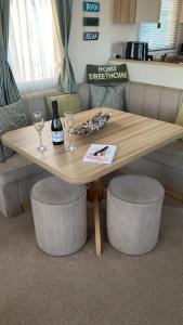 a wooden table with two glasses and a bottle of wine at Beach life in Lossiemouth