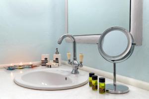 a bathroom sink with a mirror and candles on it at Yades House Paros in Naousa
