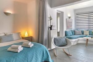 a bedroom with a bed and a chair and a couch at Yades House Paros in Naousa
