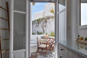 a kitchen with a door open to a patio with a table at Yades House Paros in Naousa