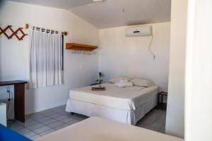 a bedroom with two beds in a room with a window at Pousada Les Alizes in Icaraí