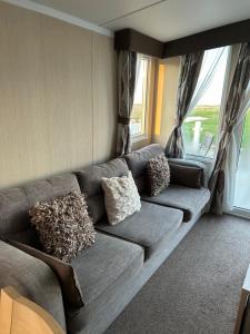 a living room with a couch with pillows on it at Sea view luxury caravan in Filey