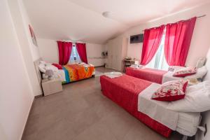 a bedroom with two beds and red curtains at Il tramonte in Vinchiaturo