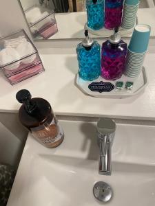 a bathroom sink with two bottles of soap and plates at Beautiful Double Room in Culloden