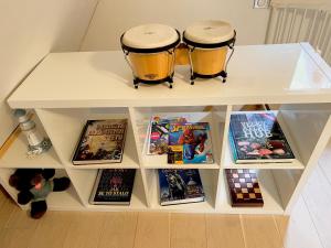 two drums sitting on top of a shelf with books at Chatka pod Lysou in Ostravice
