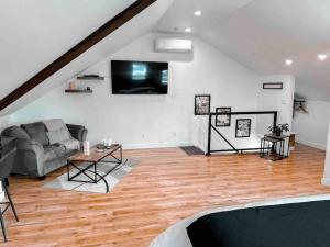 ein Wohnzimmer mit einem Sofa und einem TV in der Unterkunft Etherington Suites in Elora
