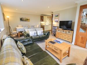 a living room with a couch and a tv at Middlerigg in Ambleside