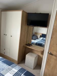 um quarto com uma cama e uma televisão na parede em 8 BIRTH LODGE ON CAYTON BAY HOLIDAY PARK em Scarborough