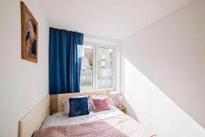 a small bedroom with a bed and a window at Grobla -Old Town by Grand Apartments in Gdańsk