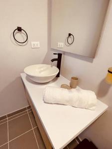 a white bathroom with a sink and a towel at APTOPOR606 - Encantador apartamento tipo loft - Chapinero - Wifi - TV in Bogotá