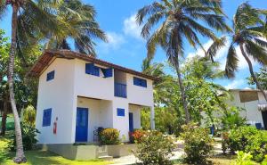 a white house with palm trees at Pousada Les Alizes in Icaraí