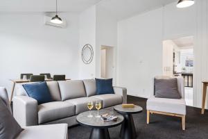 a living room with a couch and a table with wine glasses at The Tauranga on the Waterfront in Tauranga