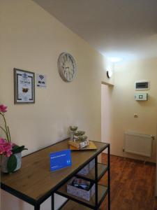 Pokój ze stołem i zegarem na ścianie w obiekcie Rebeka Guest House w mieście Trjawna