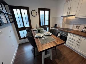 a kitchen with a table with chairs and a clock on the wall at Casa Pedro - Vallehermoso Centro Casco Antiguo in Vallehermoso