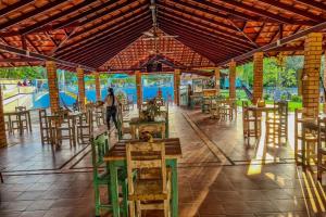 a restaurant with tables and chairs and a water park at CENTRO RECREACIONAL DEL SAN JUAN in San Juan de Urabá