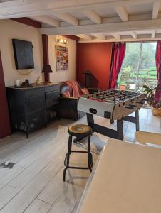ein Wohnzimmer mit Tischfußball und Hocker in der Unterkunft charmante maison Normande in Livarot