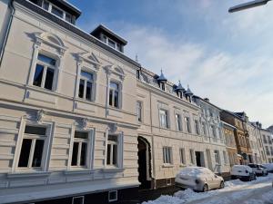 ein weißes Gebäude mit einem davor geparkt in der Unterkunft Arkadenschlösschen Bonn in Bonn