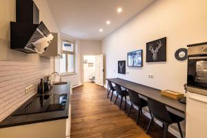 a kitchen with a long counter and some chairs at Design Appartment Altstadtperle auf Wunsch mit Parkplatz in Pirna