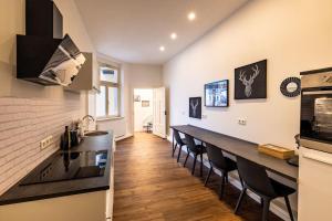 eine Küche mit einer langen Theke und einigen Stühlen in der Unterkunft Design Altstadtperle mit 2,5 Schlafzimmer- Waschmaschine - Parkplatz in Pirna