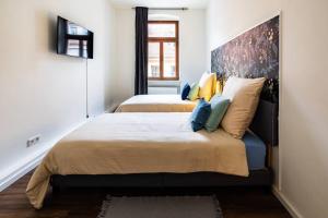 2 camas en un dormitorio pequeño con un cabecero grande en Design Appartment Altstadtperle auf Wunsch mit Parkplatz, en Pirna