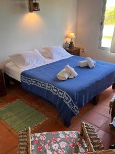 Un dormitorio con una cama azul con toallas. en Guesthouse Entre Campo y Mar, en La Coronilla