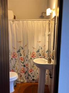 baño con lavabo y cortina de ducha en Guesthouse Entre Campo y Mar, en La Coronilla