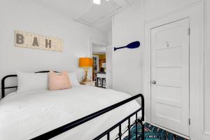 a white bedroom with a bed and a door at Splash Inn Upper Unit. Heated Pool walk to beach! in Tybee Island +26 photos
