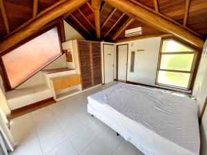 a bedroom with a bed and two windows at Ecco Village - Serrambi in Porto De Galinhas