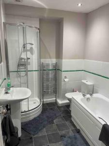 a bathroom with a shower and a sink and a tub at Cosy Gem in the heart of Glossop in Glossop