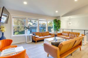 una sala de estar con muebles y ventanas de color naranja. en Modern Woodinville Home with Hot Tub and Sauna!, en Woodinville