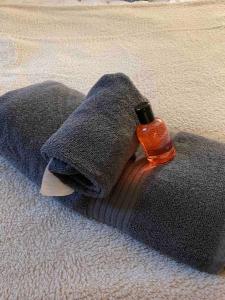 a grey blanket with a bottle on top of it at Cosy Gem in the heart of Glossop in Glossop