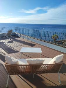 un balcón con 2 sillas blancas y el océano en Cottage Pearl - Rural Holiday Experience by SeaPearl, en Paul do Mar