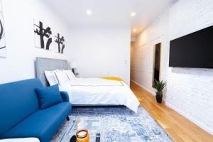 1 dormitorio con 1 cama y 1 sofá azul en 26-4A New Studio prime 20's W D Shared Courtyard en Nueva York