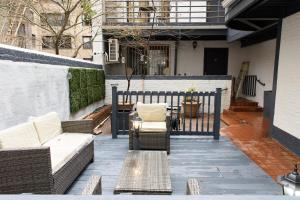 eine Terrasse mit Sofas, einem Tisch und einem Zaun in der Unterkunft 26-4A New Studio prime 20's W D Shared Courtyard in New York