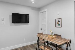 a dining room with a table and a tv on the wall at Stylish 1BR Duplex w/Free Parking & Wi-Fi in Dieppe