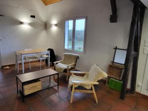 Habitación con sillas, mesas y ventana en Cottage du Diot, son lac et son île en Bannegon