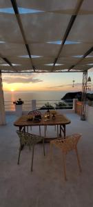 a table and a chair under a tent with the sunset at Ponza Le Forna in Ponza
