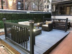 26-4B Newly Furnished 1BR W D Courtyard في نيويورك: سطح خشبي عليه طاولة وكراسي