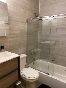 a bathroom with a toilet and a glass shower at 26-4B Newly Furnished 1BR W D Courtyard in New York