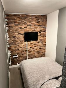 sypialnia z telewizorem na murze w obiekcie Petite maison de ville avec cour w mieście Saint-Nazaire