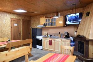 a kitchen with a table and a tv on the wall at Rebeka Guest House in Tryavna +47 photos