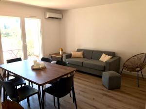 a living room with a table and a couch at Résidence Fiori di Cala Rossa in Lecci