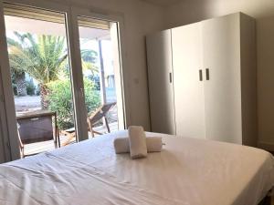a bedroom with a white bed and a large window at Résidence Fiori di Cala Rossa in Lecci +8 photos
