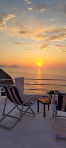a patio with chairs and a table and the sunset at Ponza Le Forna in Ponza