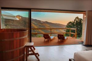 a room with a balcony with a view of a mountain at Carvalheira Country House - Gerês in Braga