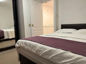 1 dormitorio con cama y espejo en 30% Off Monthly Stay/2bed /Erith en Erith